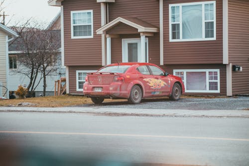 Modern car on pavement against residential house facades in town