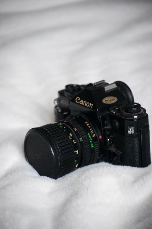 Free Photo of a Black Camera on a White Textile Stock Photo