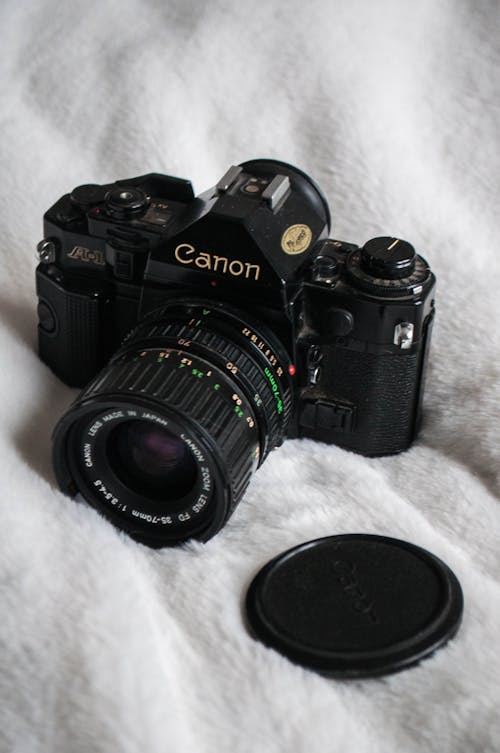 Close-Up Photo of a Canon Camera on a White Blanket