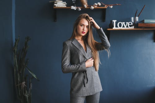 Photograph of a Woman in a Gray Blazer Posing with Her Hand on Her Head