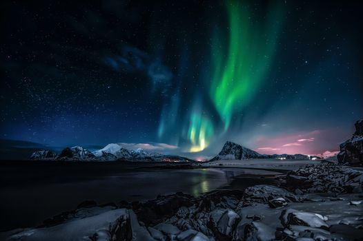 Breathtaking view of the Northern Lights illuminating the snowy landscape of Nordland, Norway.