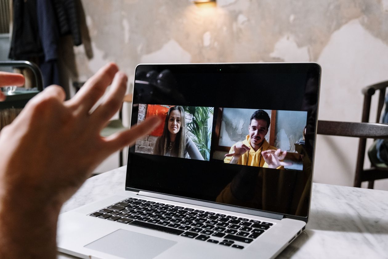 Hands gesturing during a video call on a laptop