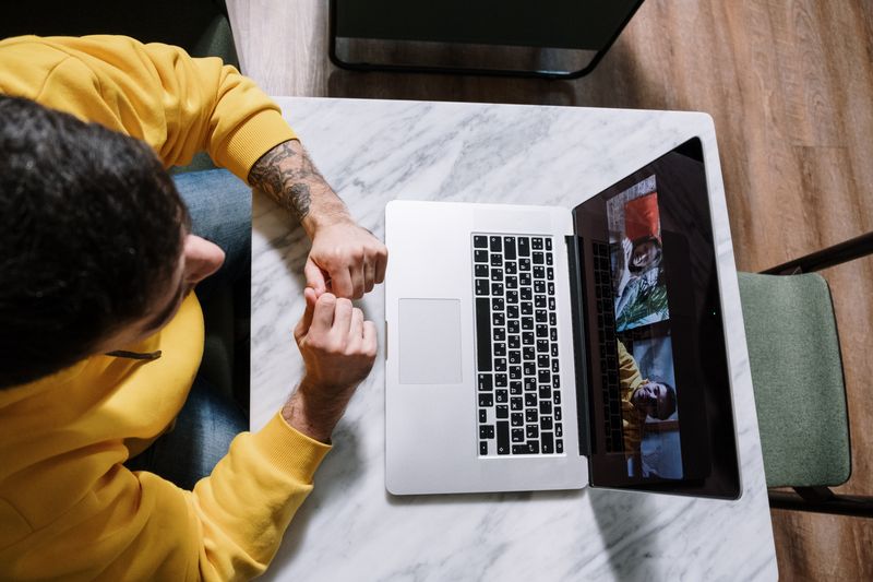 Doi cursanți urmărind o lecție de germană pe laptop