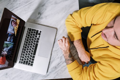 Persona Con Camisa Amarilla De Manga Larga Con Macbook Pro