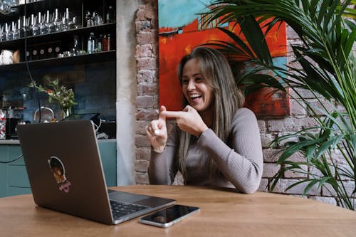 Frau Im Grauen Pullover Sitzt Am Tisch Mit Macbook Pro