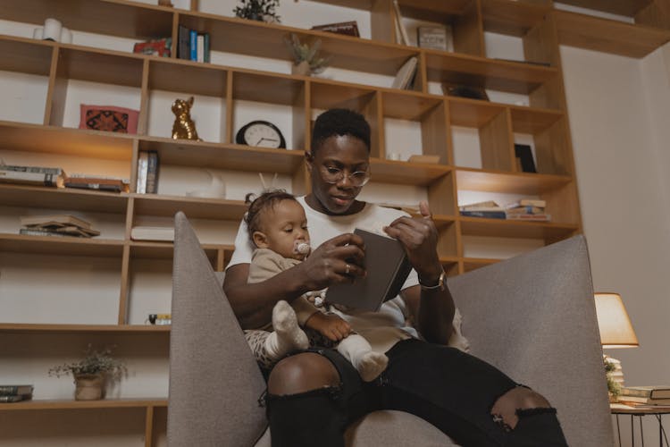 A Father Reading A Book With His Baby