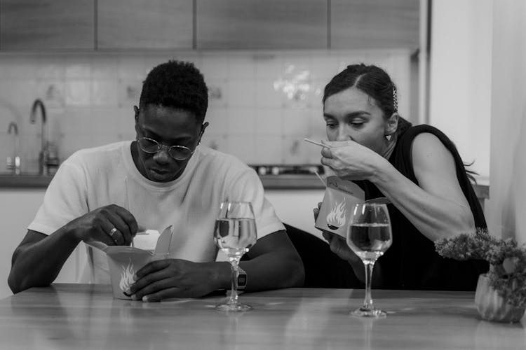 Grayscale Photo Of Couple Eating