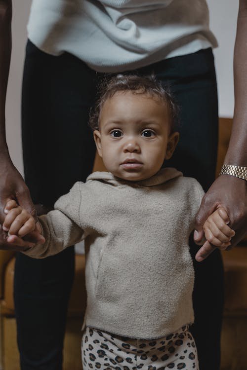 Free A Toddler Standing with Her Father's Support Stock Photo