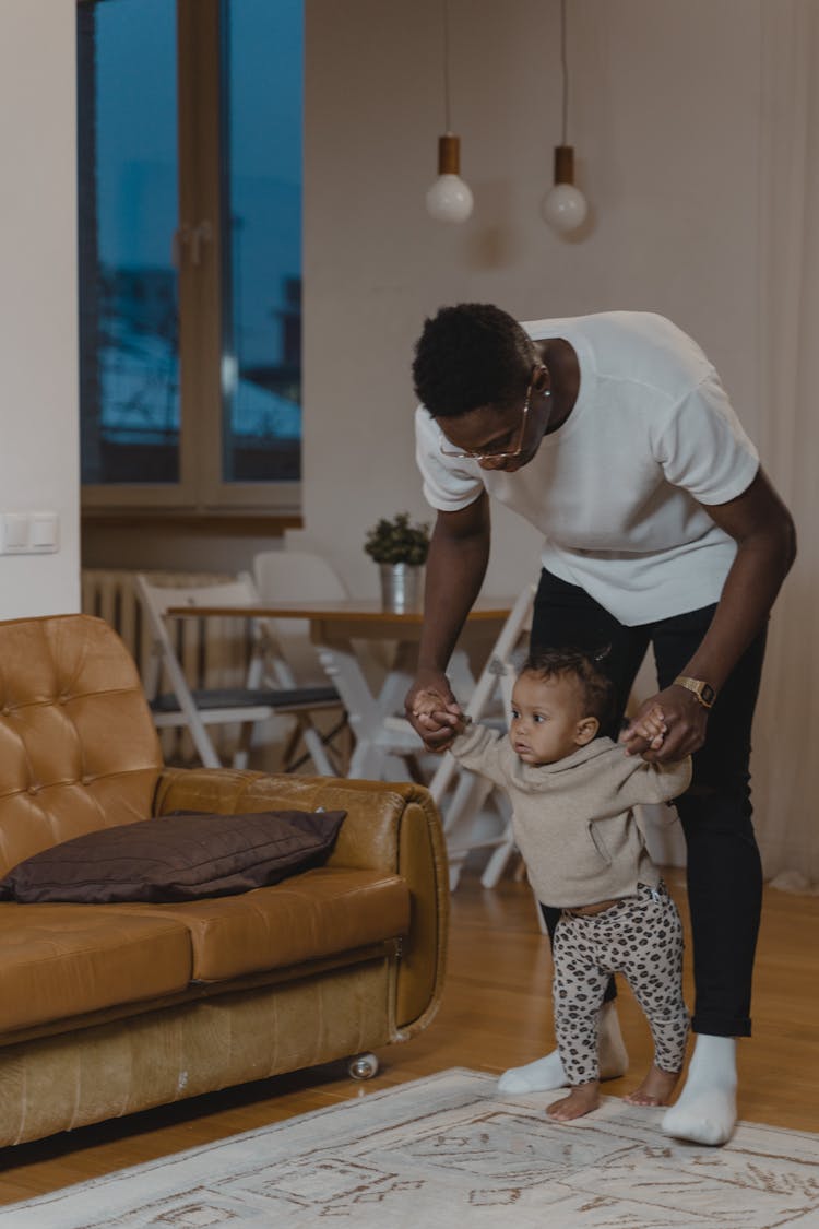 A Man Holding A Baby While Walking