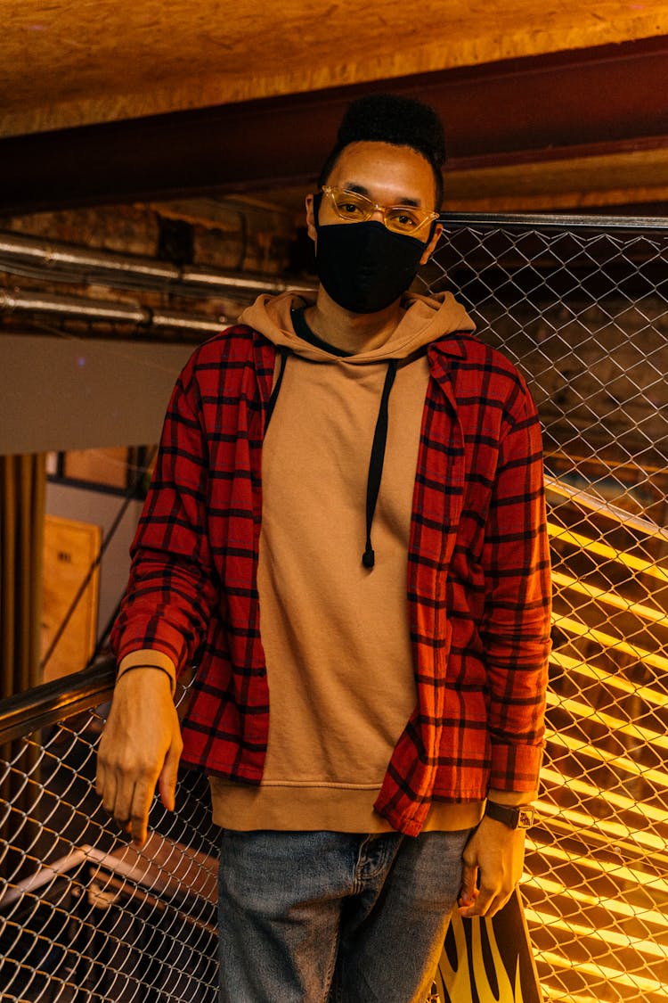 Masked Man In Eyeglasses Standing In Warehouse Room 