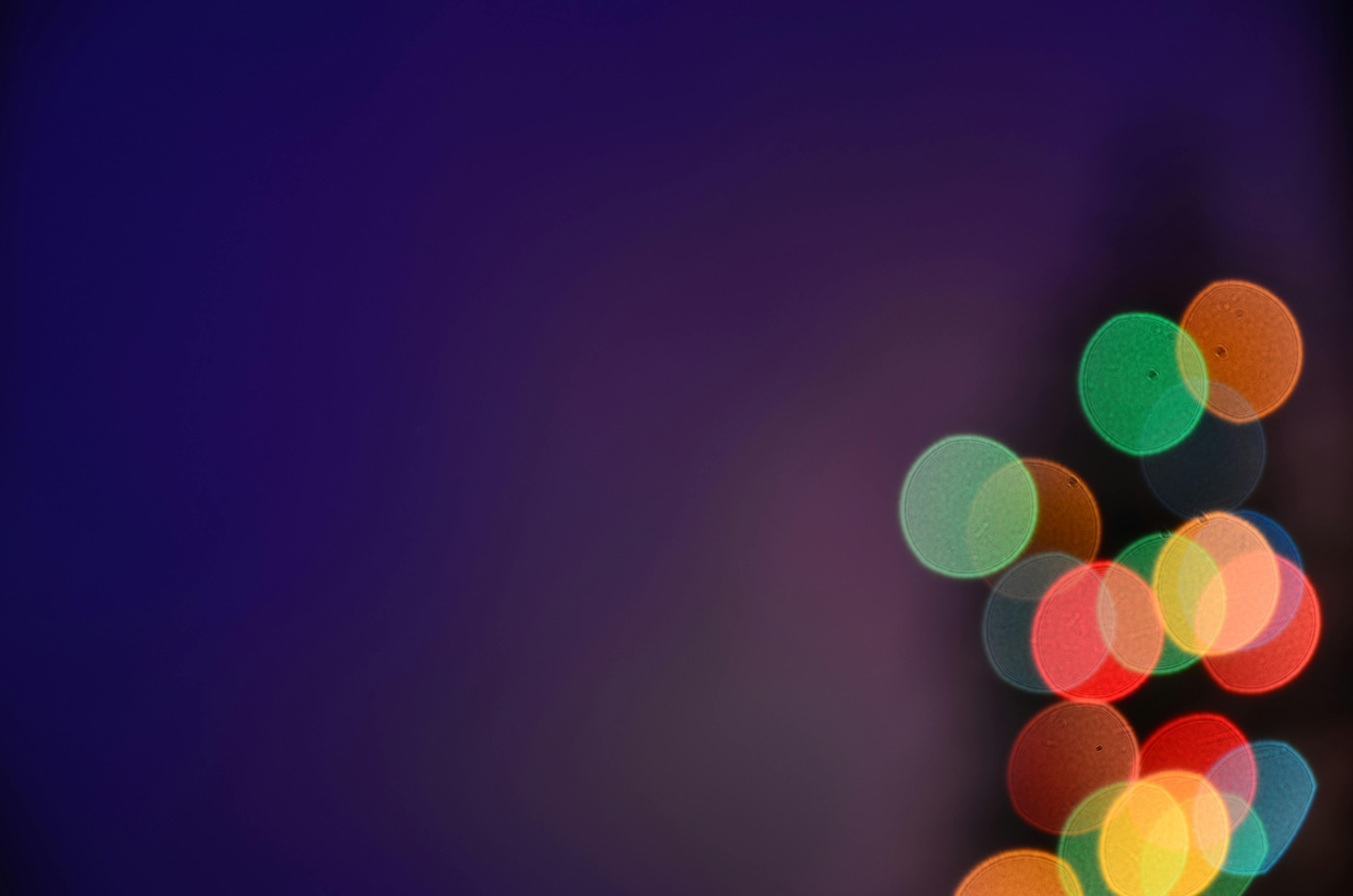 Colorful bokeh lights on a dark background create a vibrant abstract image.