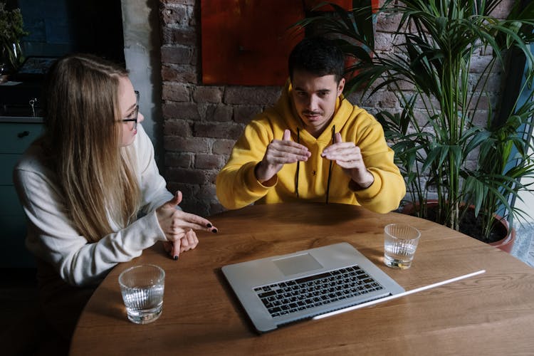 Man And Woman Sitting At Table Having A Conversation