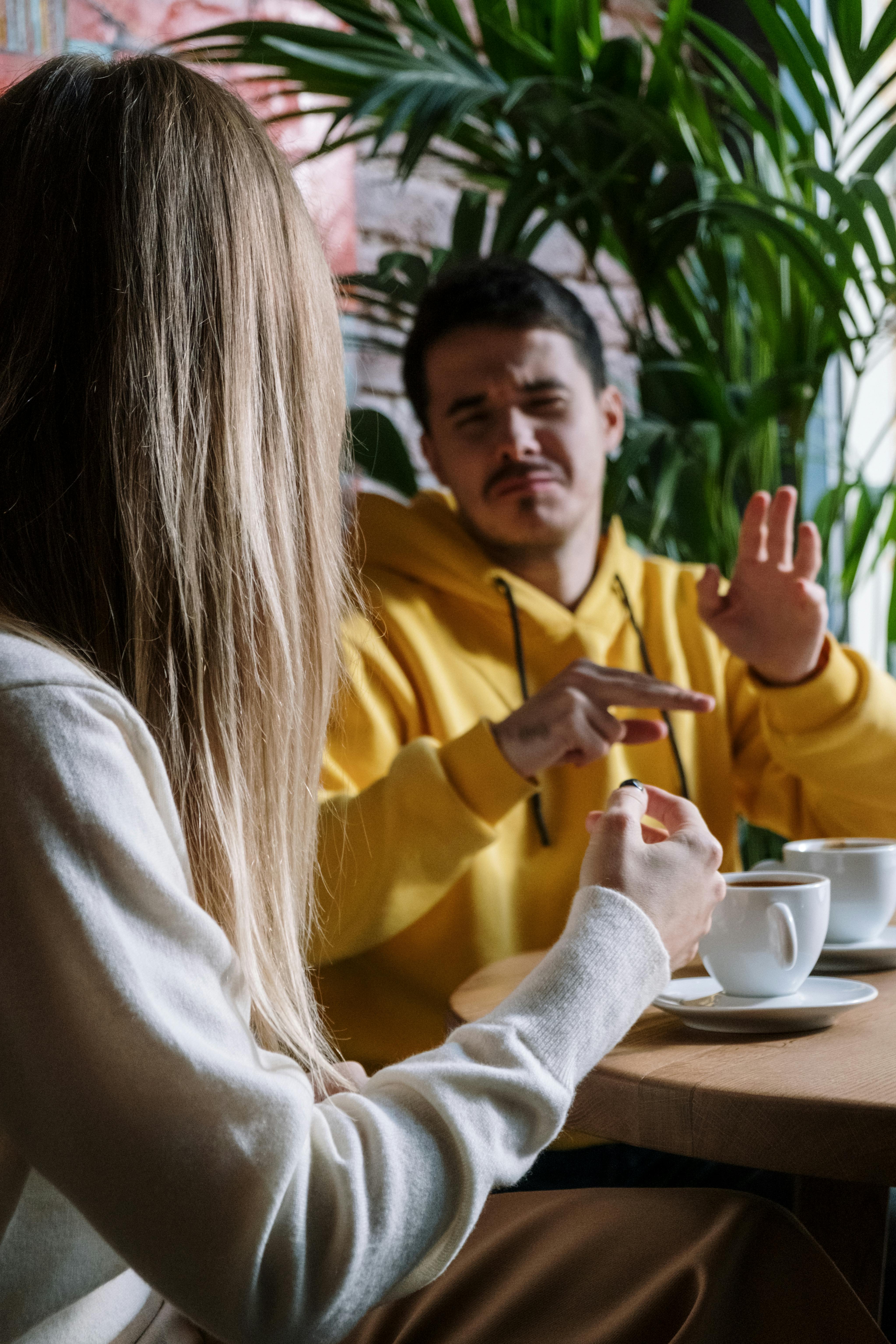 man and woman communicating through hand gestures