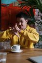 Man in Yellow Hoodie Doing Sign Language
