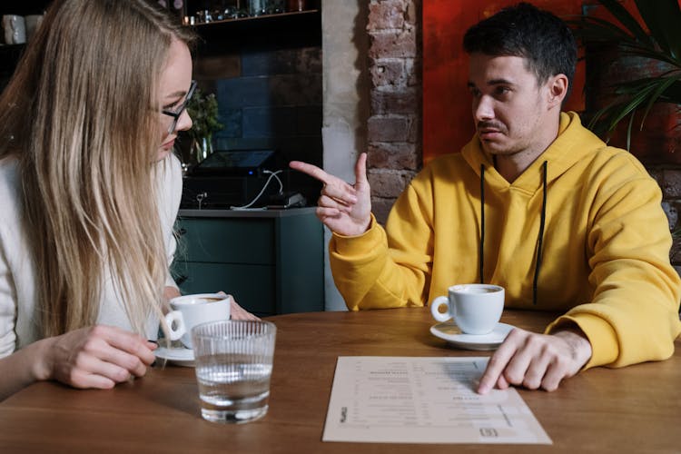 Man And Woman Sitting At Table Having A Conversation