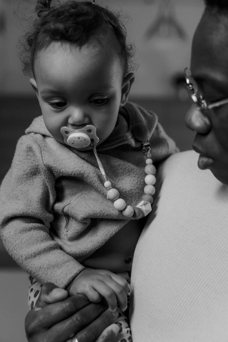 Grayscale Photo Of Man Carrying A Baby