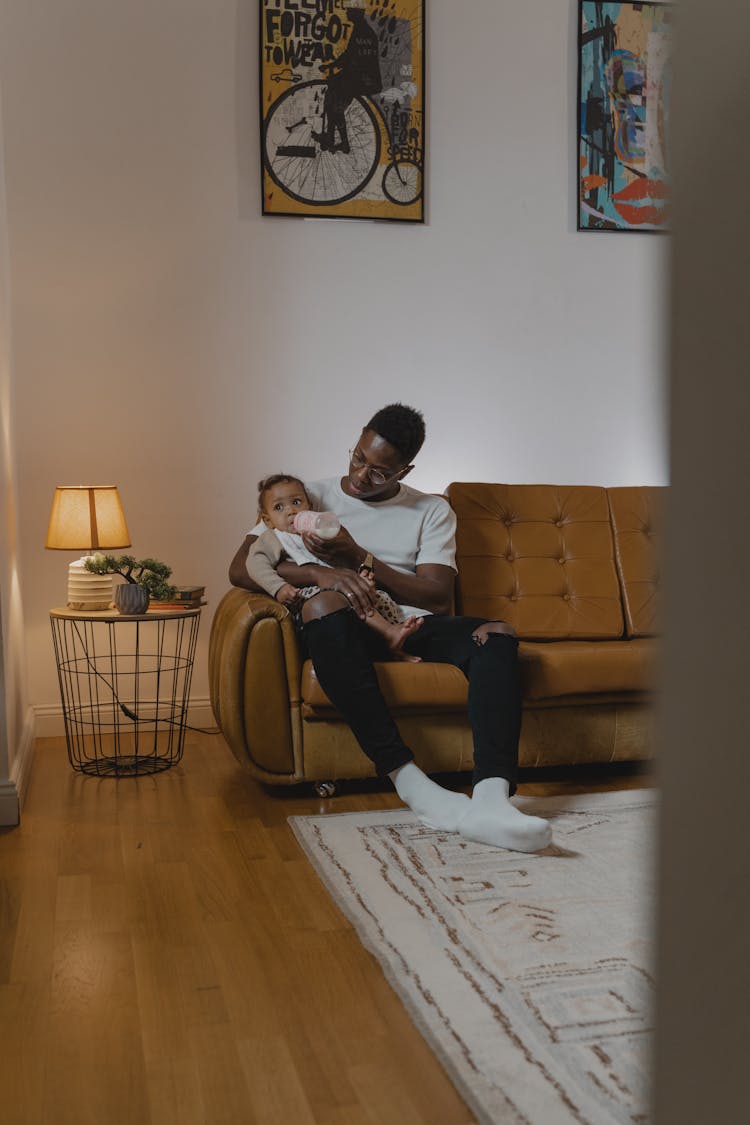 Person In White Shirt Feeding A Toddler