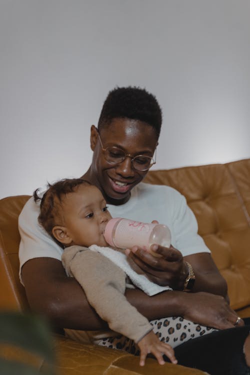 Man in White Shirt Feeding a Toddler