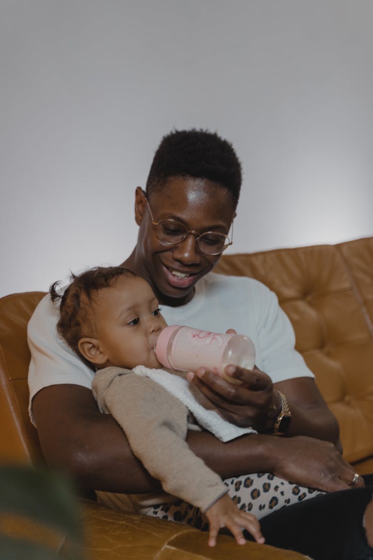 Man In White Shirt Feeding A Toddler