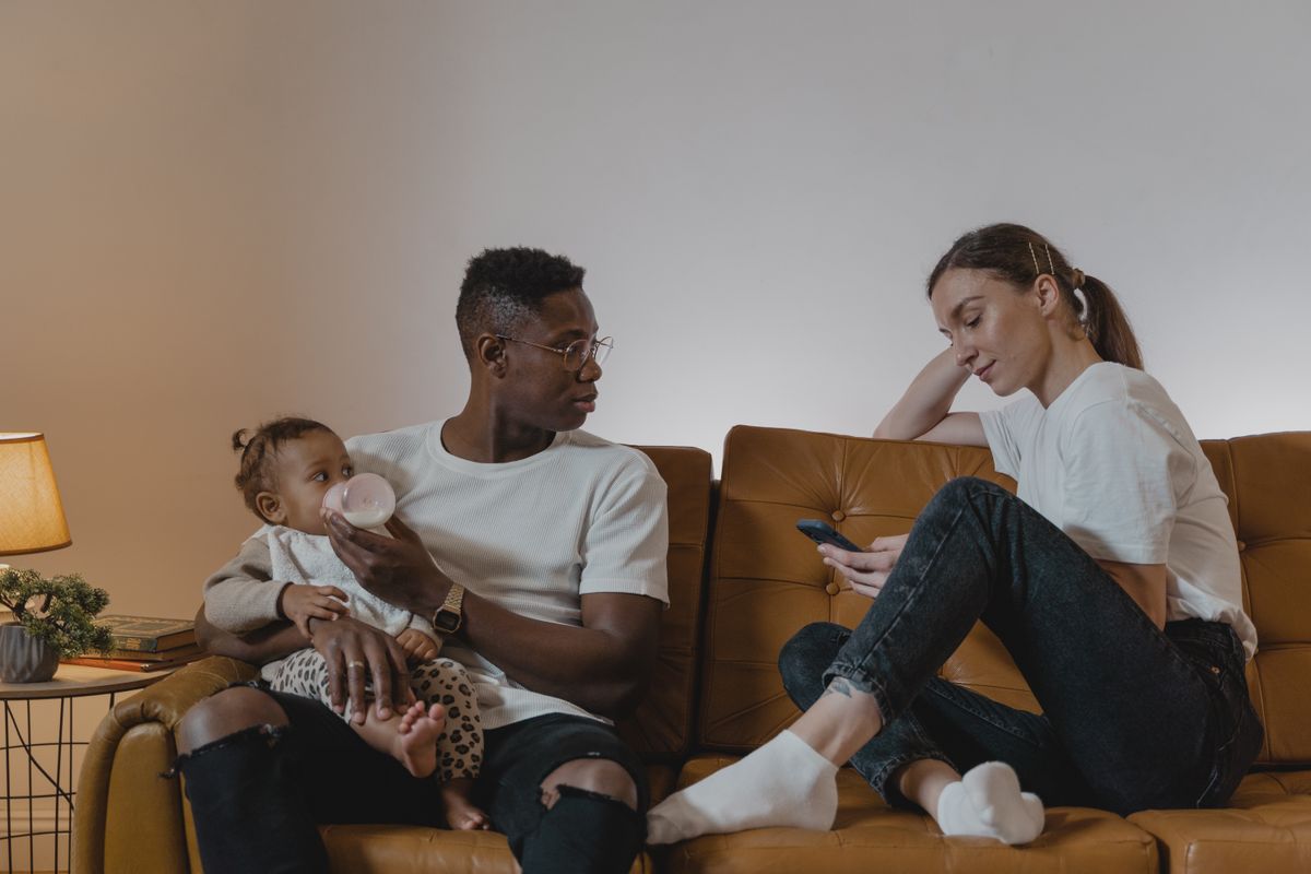Parent talking and bonding with their baby on a sofa