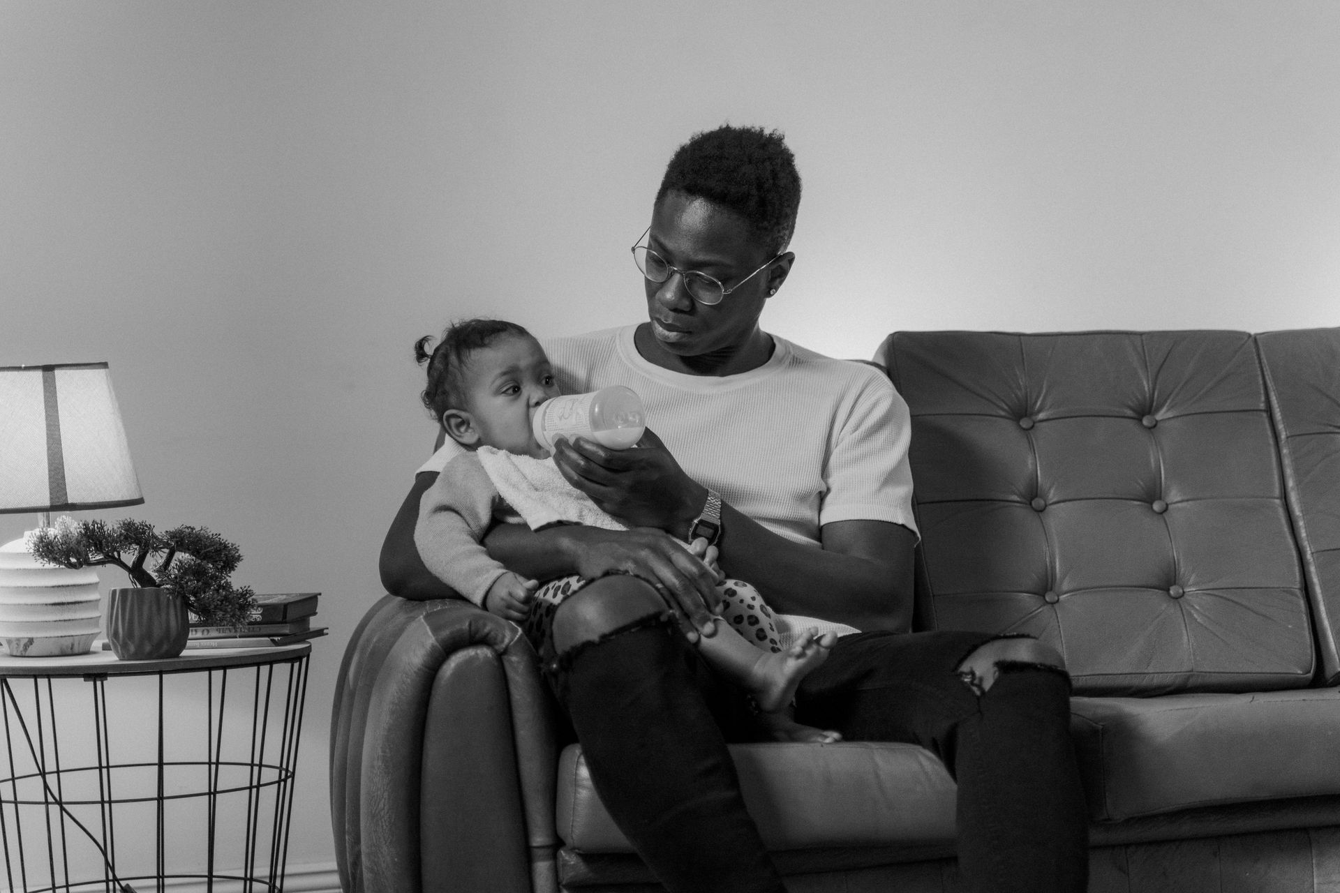 Black and White Photo of a Man Feeding a Toddler