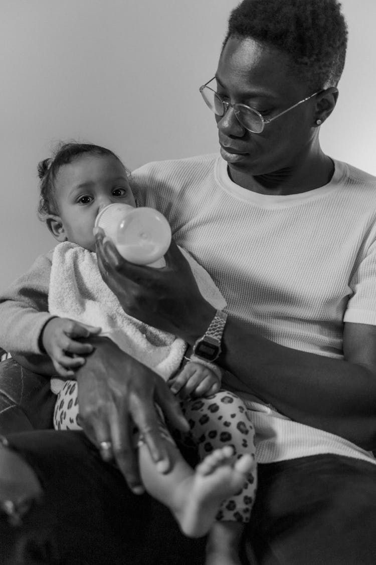 Black And White Photo Of Man Feeding A Toddler