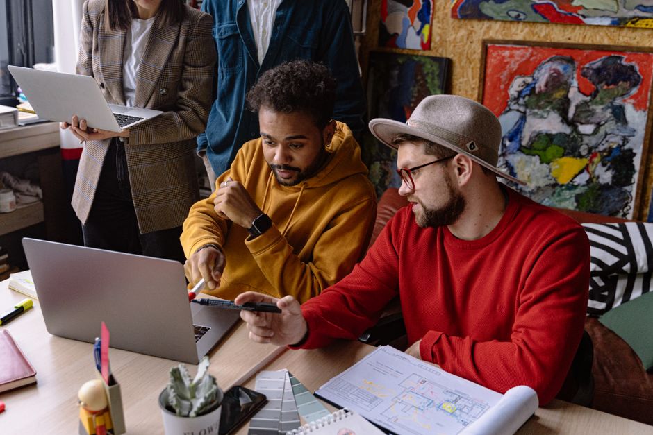Diverse team in casual attire collaborating on a project in a creative workspace.