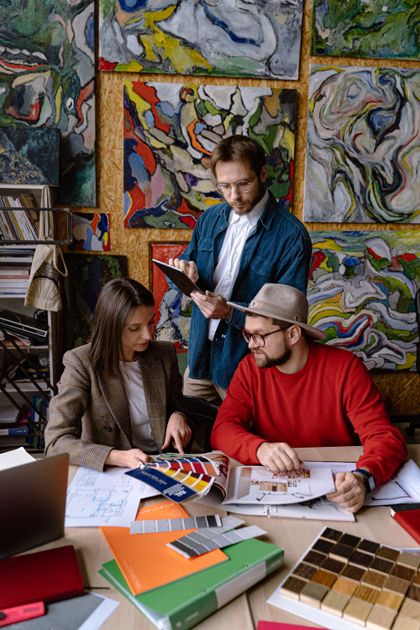 Three makers reviewing colour and material swatches — AI25.Studio on Pexels
