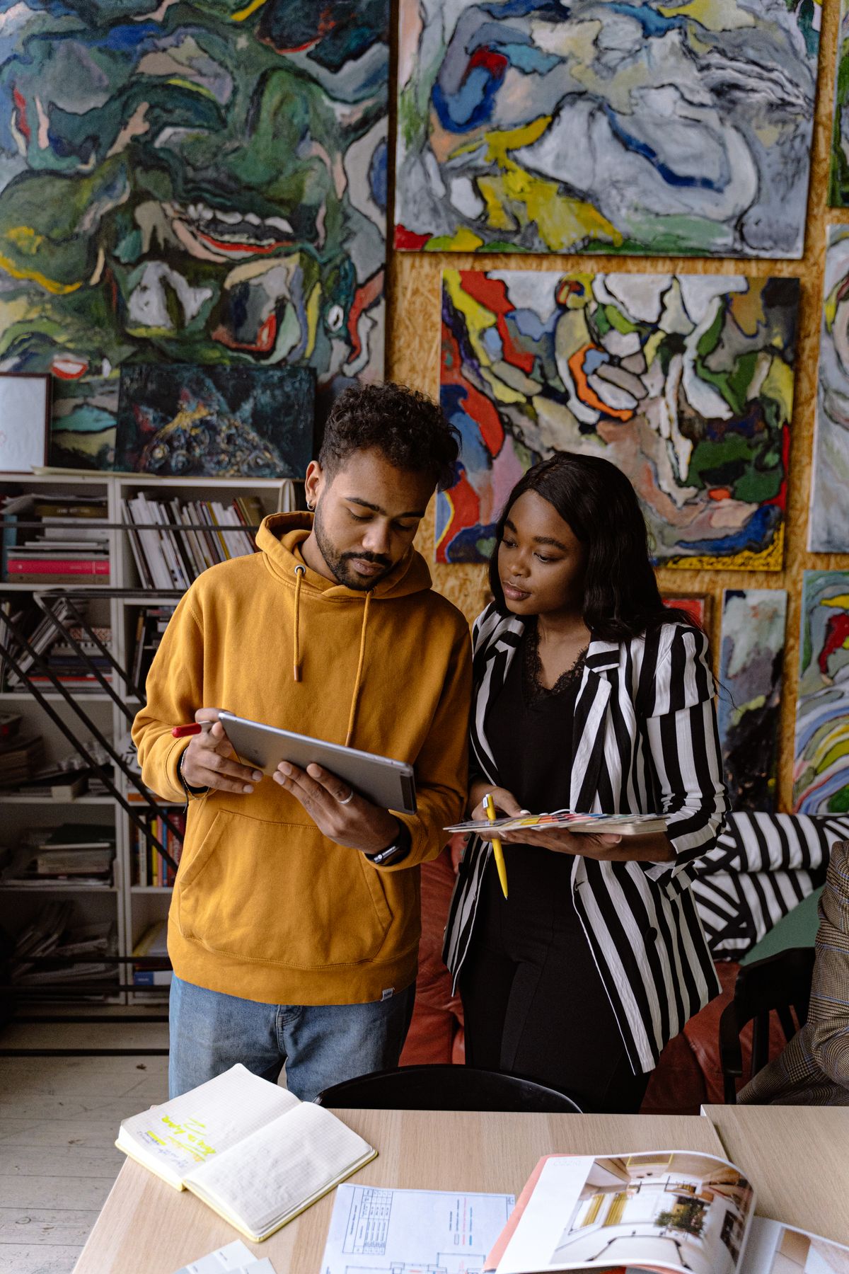 Twee ontwerpers wisselen ideeën uit in een studio met kunst en ontwerpobjecten