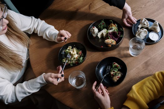Group gathered around a table sharing a meal with diverse dishes.