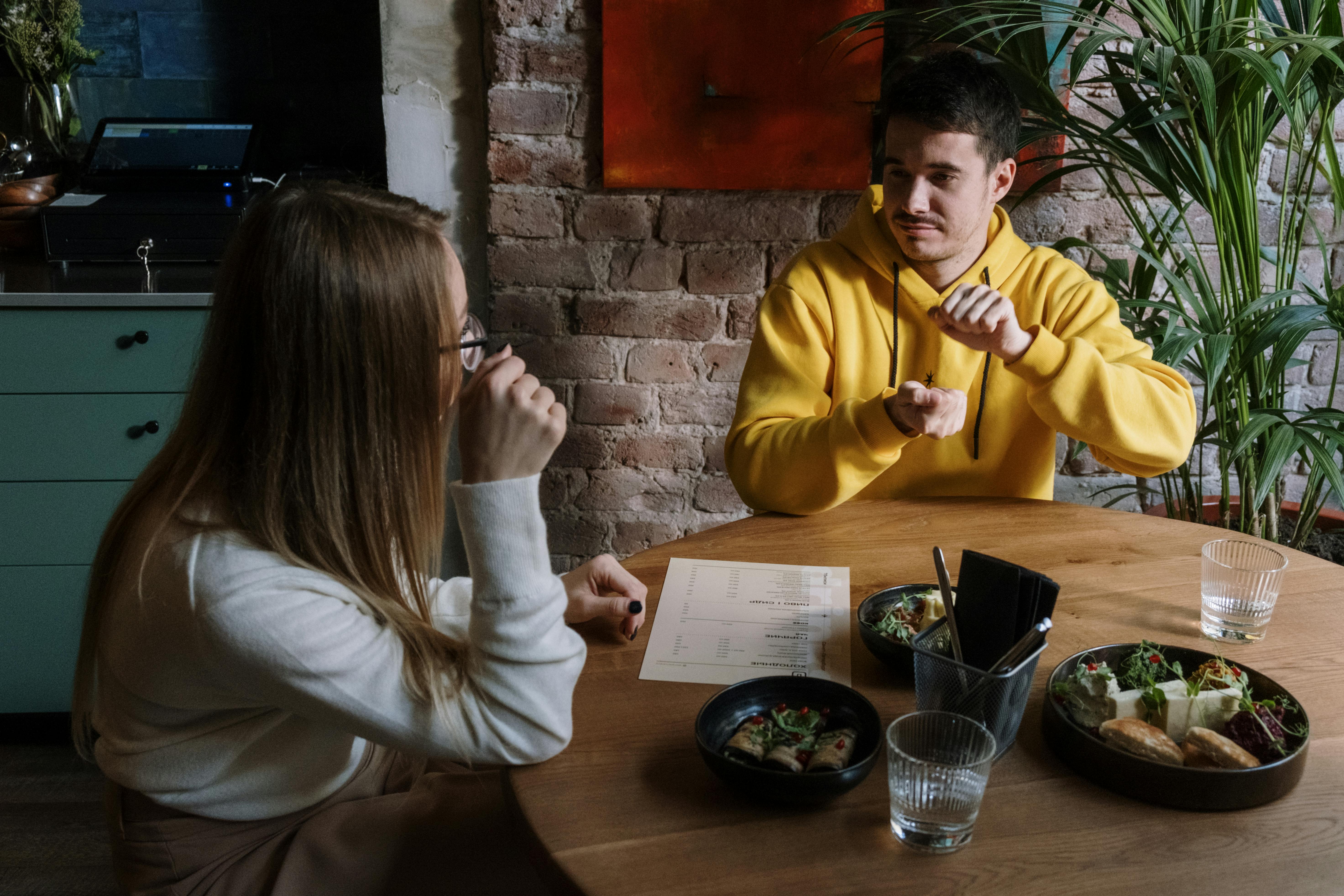 woman in white long sleeve shirt sitting beside man in yellow sweater