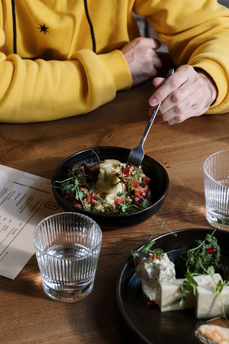 Person In Yellow Sweatshirt Eating Salad