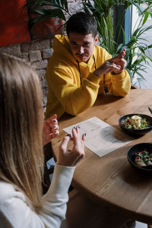 A Man and a Woman Communicating Through Hand Gestures · Free Stock Photo