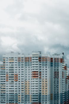 Exterior of high modern colorful residential building with balconies located in megapolis district on cloudy day in daytime