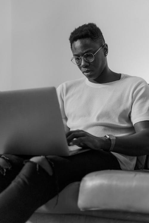 Black and White Photo of a Man Using a Laptop