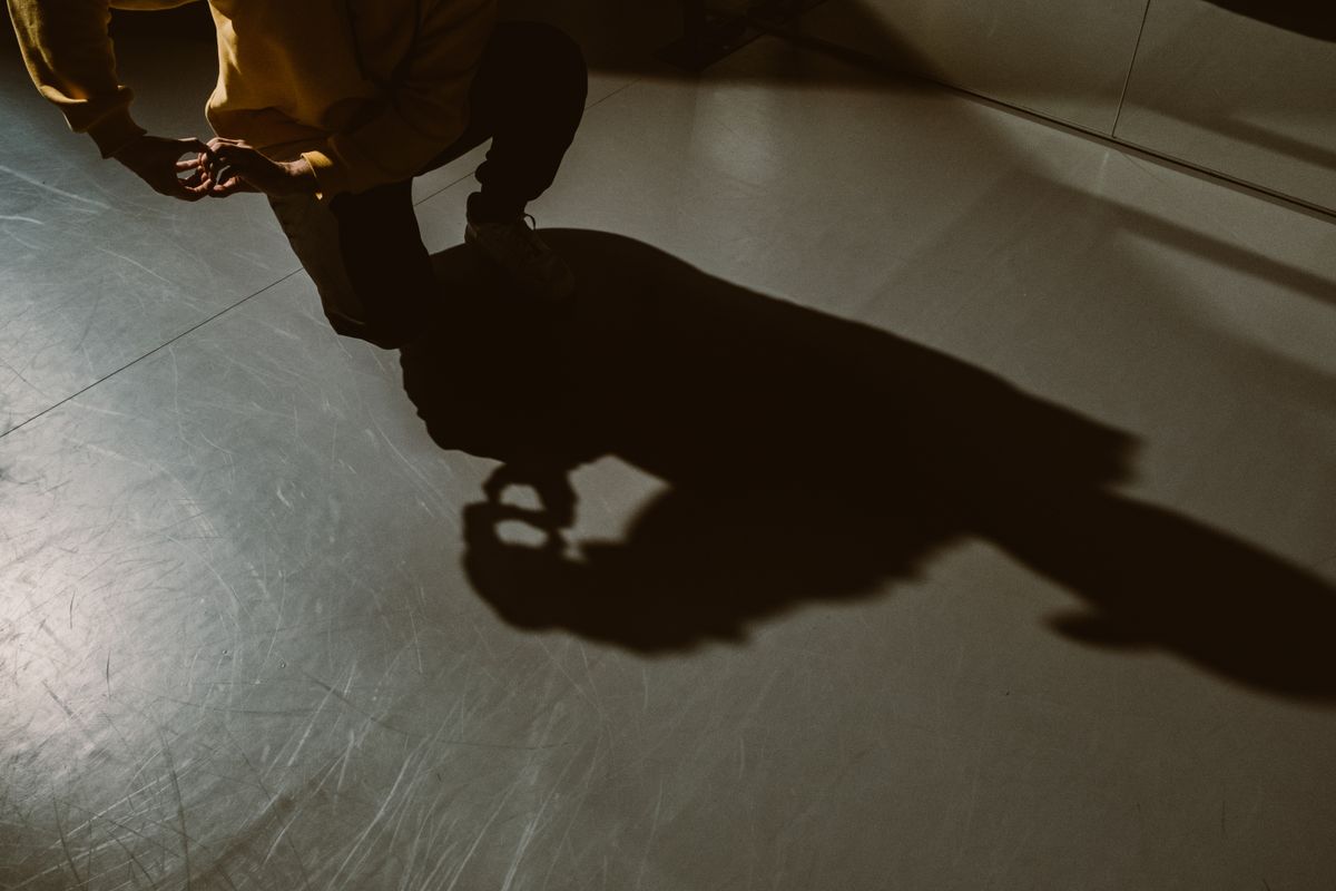 Bayangan seseorang berlutut sembunyi di belakang dinding gelap suasana stealth