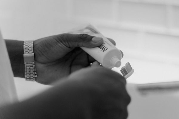 Hands applying toothpaste to a brush — photo by Tima Miroshnichenko on Pexels