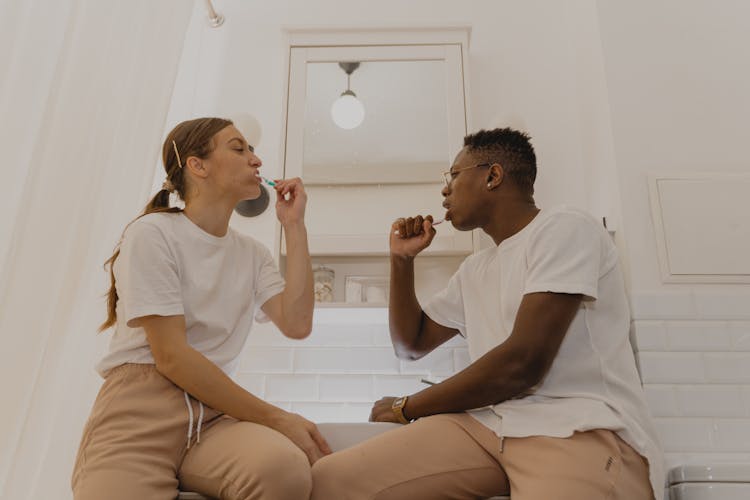 A Couple Brushing Their Teeth Together