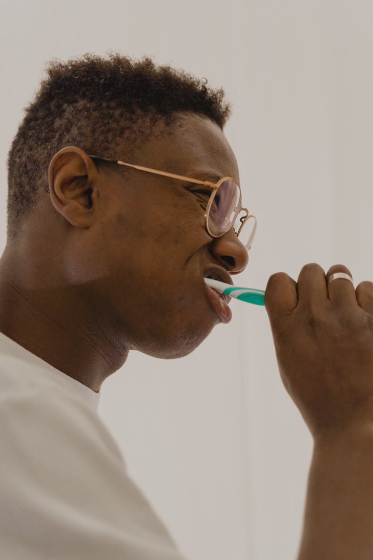 Side View Of A Man Brushing His Teeth