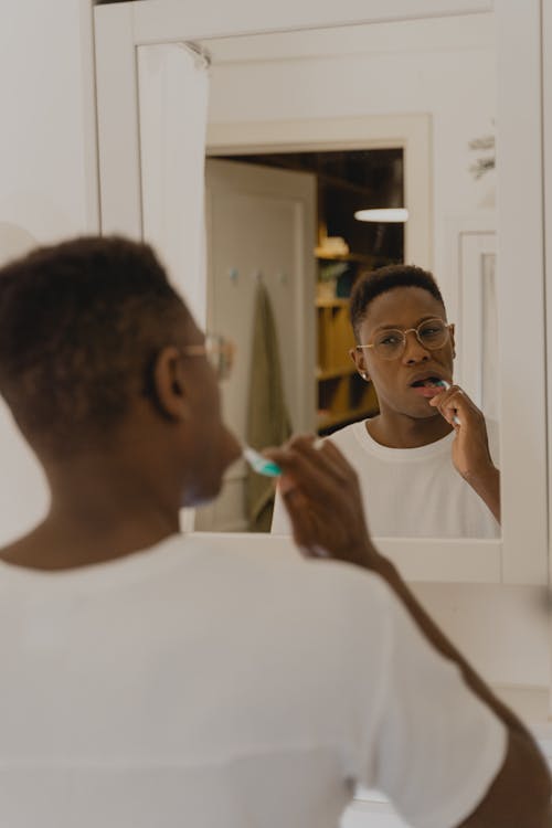 A Reflection of a Man Brushing his Teeth