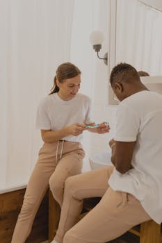 Couple in bathroom promoting dental hygiene, sharing a morning routine and toothbrushes.