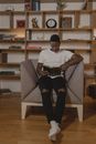 Man in White Crew Neck T-shirt Sitting on Gray Chair