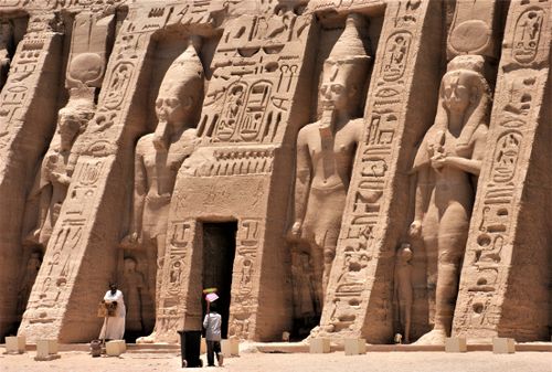 Free Exterior view of an ancient Egyptian temple featuring hieroglyphics and carved statues. Stock Photo