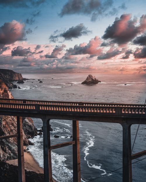 Free A breathtaking view of Bixby Creek Bridge against a dramatic sunset sky on the California coast. Stock Photo