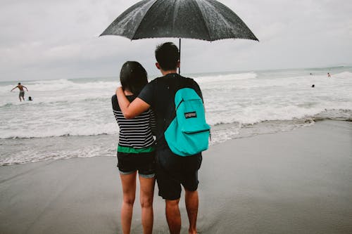 Free Man and Woman Standing on Shore Stock Photo