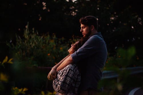 Loving young couple cuddling and enjoying sunset in nature