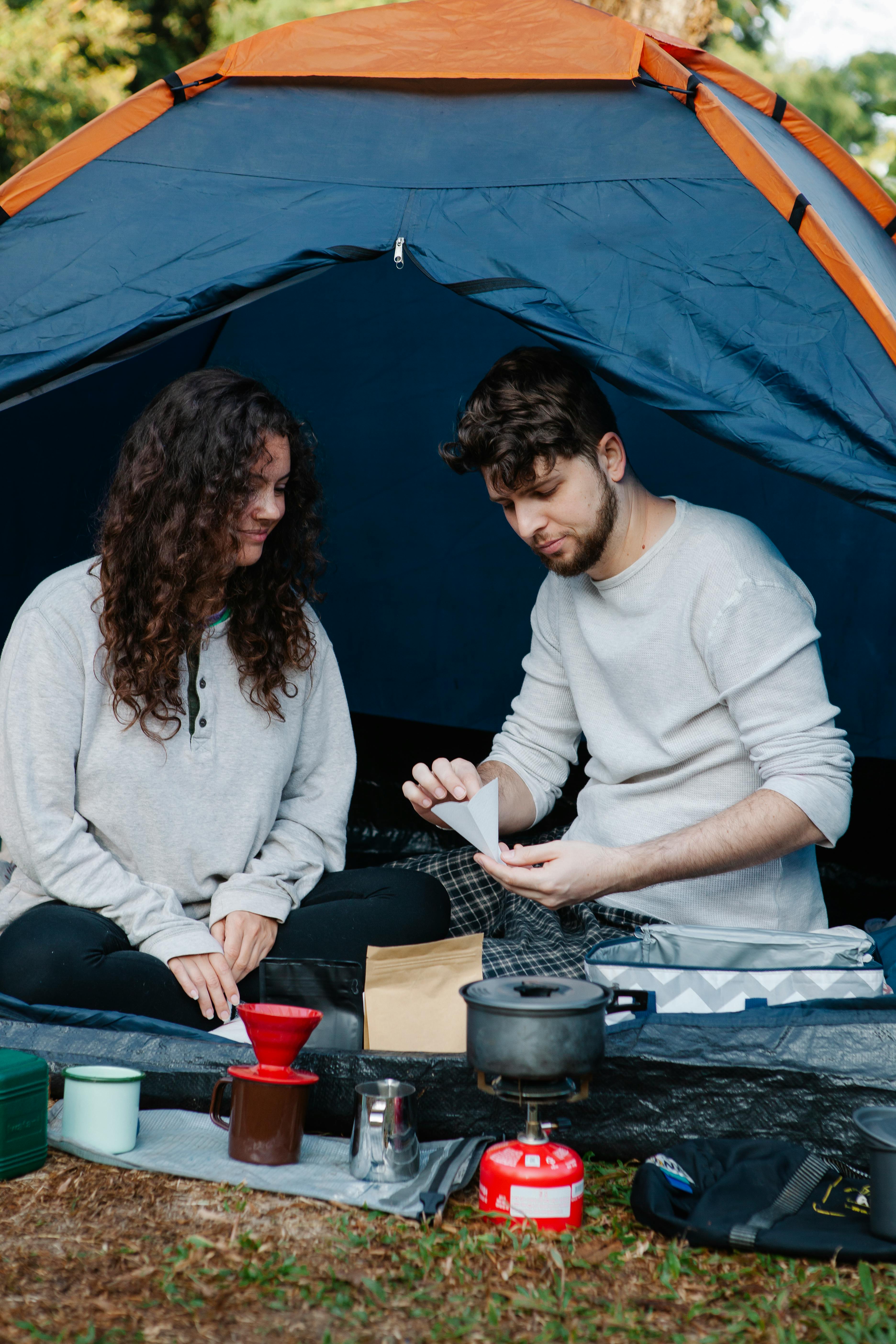 travelers with filter preparing coffee in tent