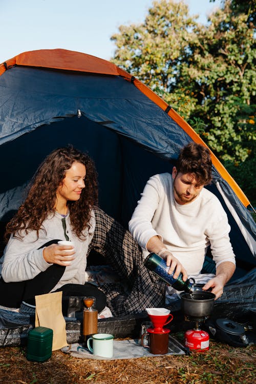 Free Couple of hikers preparing coffee in campsite Stock Photo