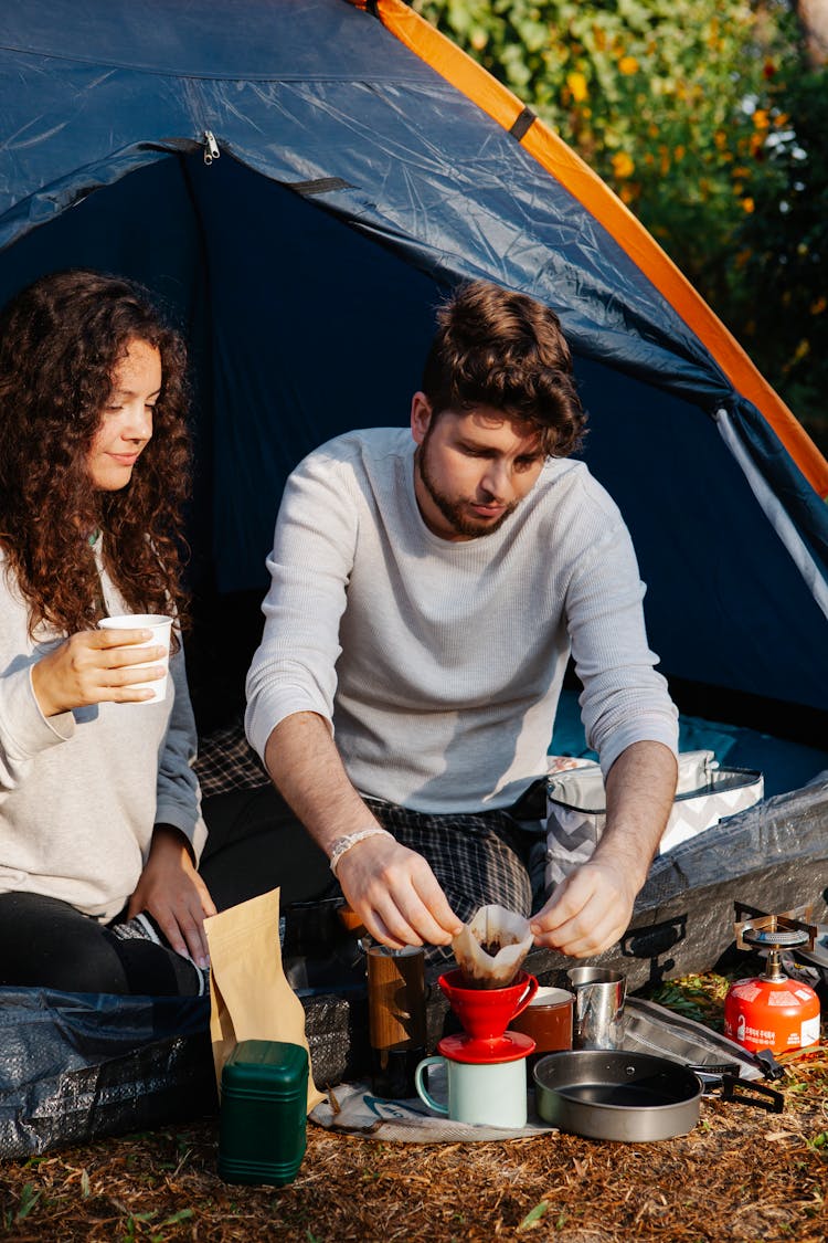 Hikers Brewing Coffee In Drip Maker In Tent