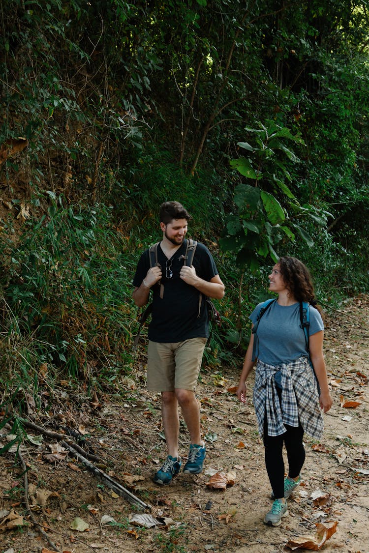 Hikers Talking While Walking On Path In Woods